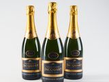 three bottles of champagne sitting on top of a white surface