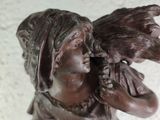 a statue of a woman holding a bird in her hand