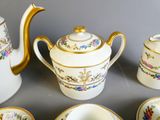 une théière, des tasses et des soucoupes posées sur une table