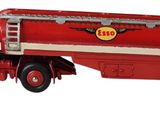 un camion jouet rouge et blanc avec une étiquette jaune dessus