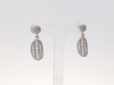 une paire de boucles d'oreilles en diamant posée sur un présentoir, sur fond blanc