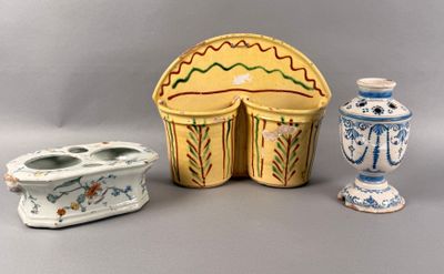 three vases and a candle holder sitting on a table