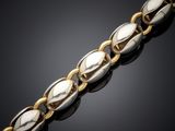 a close up of a gold and silver bracelet on a black surface