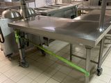 a large stainless steel table in the middle of a kitchen