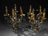 pair of brass and crystal sconces on a black background