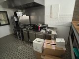 Des cartons sont empilés par terre dans la cuisine d'un restaurant