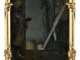 un grand miroir avec un cadre doré accroché au mur