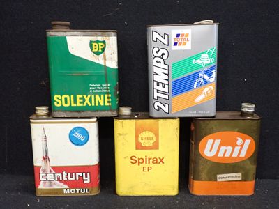 cinq boîtes d'huile posées sur une surface noire