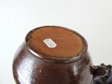 a brown vase sitting on top of a table with a tag on it