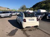 a white car parked in a parking lot next to other cars