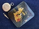 a small purse with a gold and black design on it