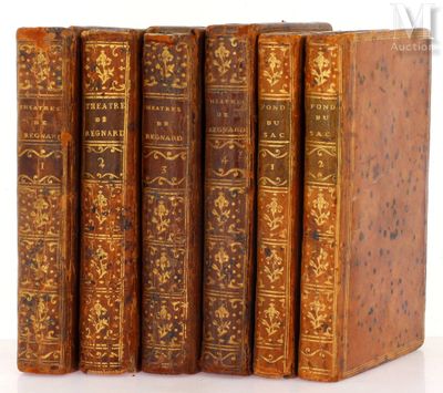 trois vieux livres posés l'un sur l'autre sur une surface blanche
