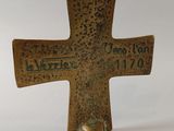 an old bronze cross with the inscription of person on it