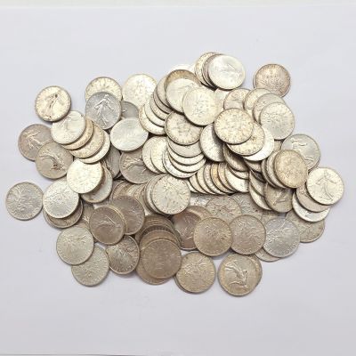 une pile de pièces d'argent posée sur une surface blanche