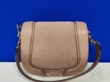 un sac à bandoulière en cuir rose posé sur une table blanche