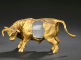 brass figurine of a bull with a stone in its back