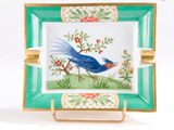 une image représentant un oiseau bleu sur une assiette verte et dorée