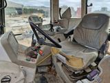 two seats on the back of a bus that is sitting in the dirt