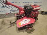 an image of a small tiller in a garage