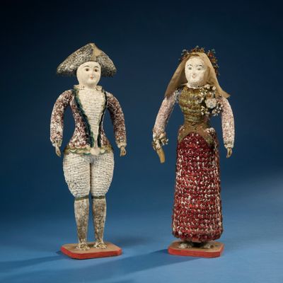 deux figurines représentant un homme et une femme debout l'un à côté de l'autre sur un fond bleu