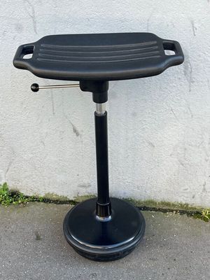 Tabouret en plastique noir, pied ronds sur coussinet en caou…