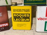 three cans of motor oil sitting on the ground next to each other