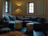 a living room with a couch, chair, ottoman, table and lamp