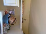 a small white cabinet in the corner of a room