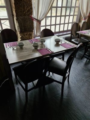 une salle à manger avec une table et des chaises, ainsi qu'une grande fenêtre