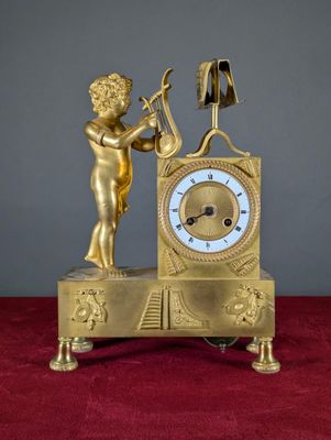 une horloge en or surmontée d'une statue