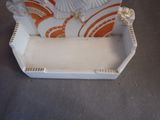 a white and orange vase sitting on top of a table