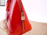 someone is holding a red purse with a zipper on it