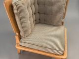 a small chair with a cushion on it and a pillow on the back
