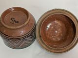 two brown bowls sitting next to each other on a table