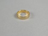 a close up of a gold ring on a white surface