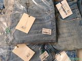 a pile of jeans with tags on them sitting on a table