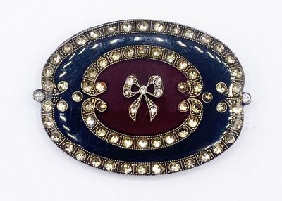 une photo d'une broche ornée d'un nœud