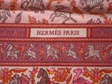 a close up of a pink and orange fabric with horses