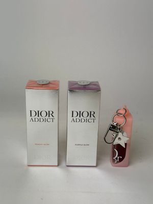 un flacon de parfum et un porte-clés posés l'un à côté de l'autre sur une surface blanche