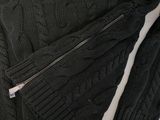 a close up of a black sweater with a zipper on it