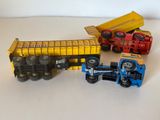 trois camions jouets et un camion-benne posés sur une table