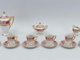 a group of pink and white porcelain tea and coffee cups and saucers