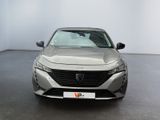 the front of a silver car in a room with a white wall