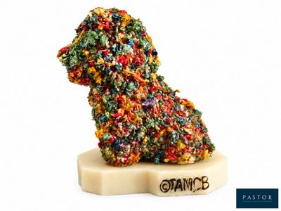 un petit chien fait de bonbons posé sur un bloc