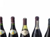 six bottles of wine are lined up in a row on a table