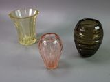 three different colored glass vases sitting on a table