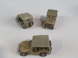 four toy army vehicles that are sitting on a white surface
