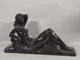 statue of a woman reclining on a chair on a white background