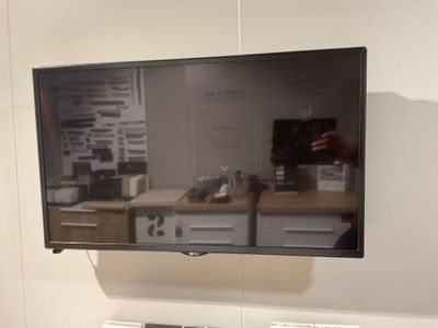 une télévision à écran plat fixée au mur au-dessus d'un bureau