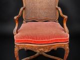 une vieille chaise avec un coussin rouge sur fond noir